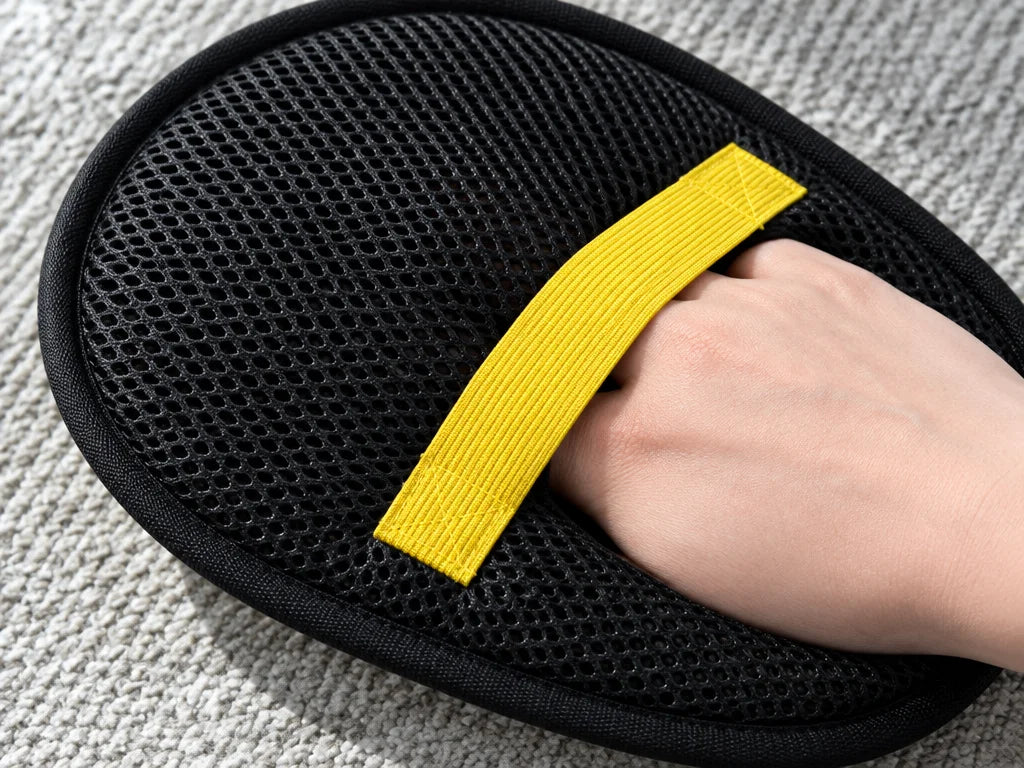 A wide 4:3 macro photograph of the exact brush’s reverse side: black mesh fabric and its yellow elas